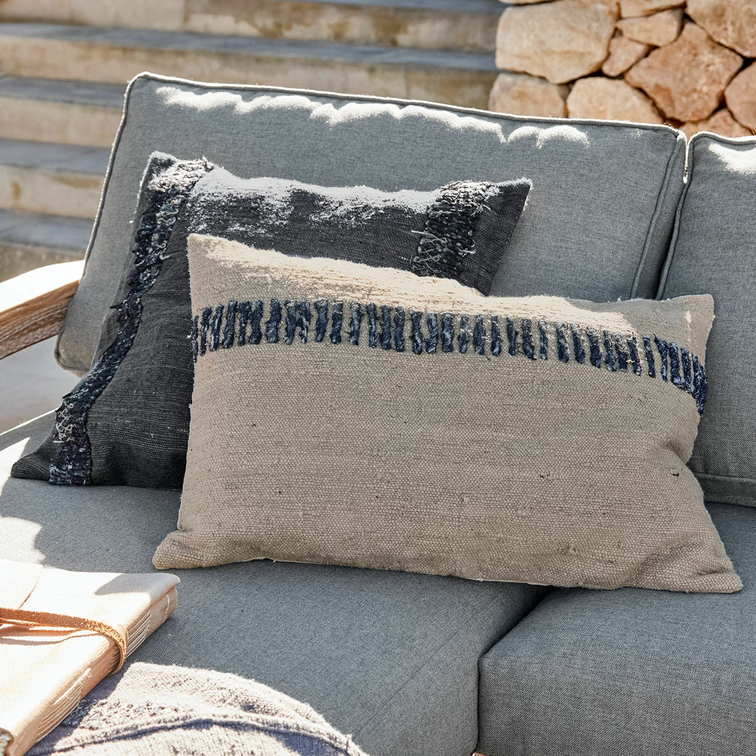 Coppia di copricuscini Foix Cuscini decorativi beige e neri in tessuto su divano grigio da esterno, tessili per soggiorno