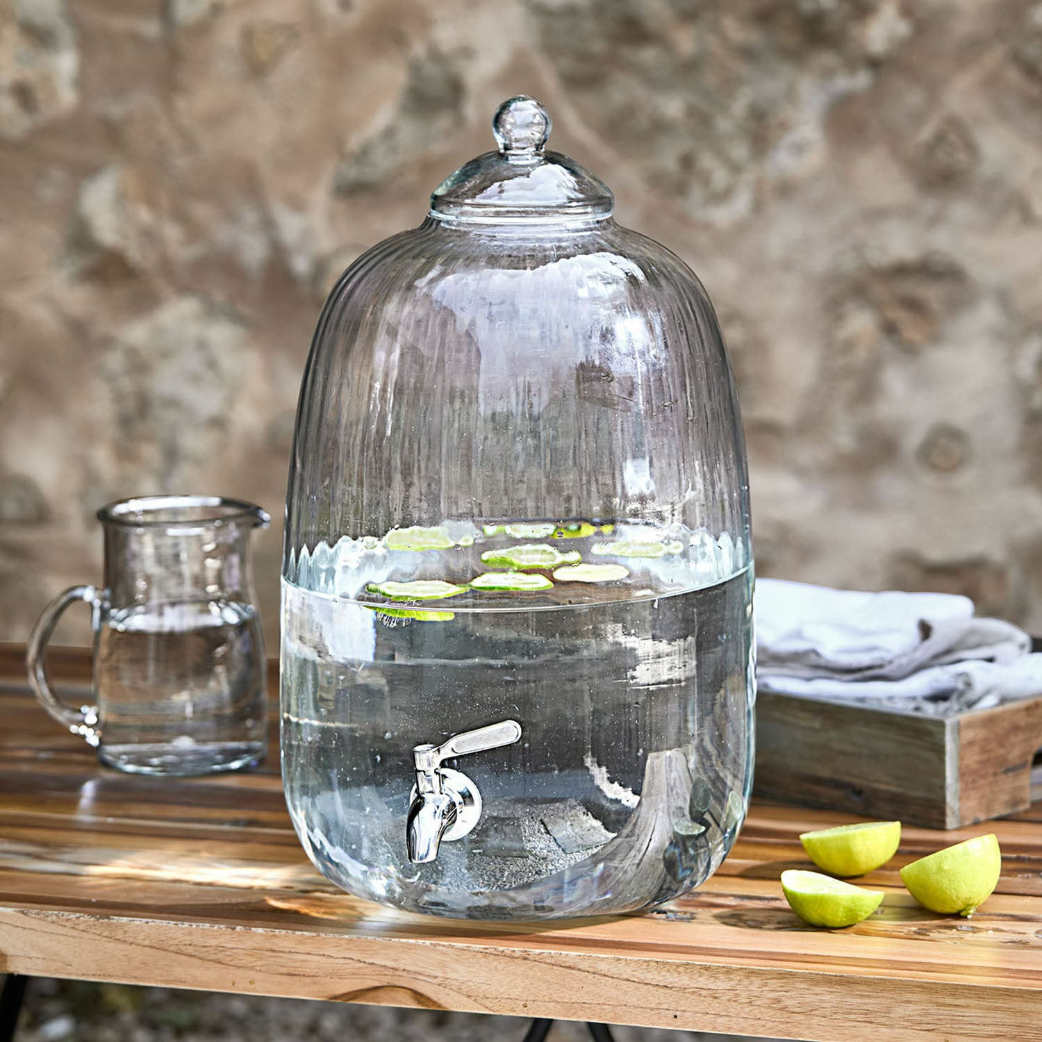 Dispenser di bevande Alindor Dispenser d'acqua in vetro trasparente con rubinetto e coperchio, fette di lime galleggianti sul tavolo