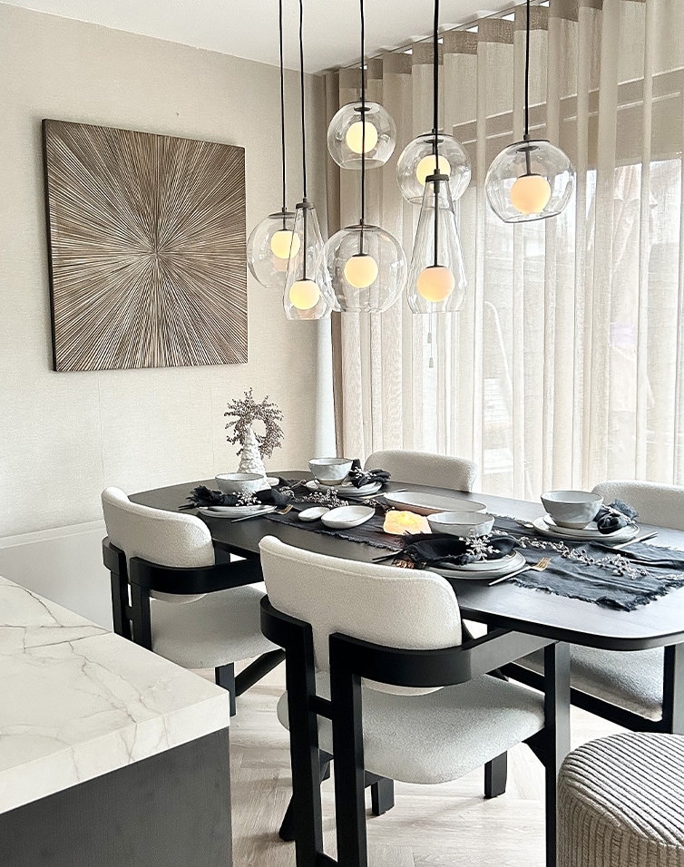 Tavolo da pranzo nero moderno con sedie bianche e lampade a sospensione in vetro in interno luminoso