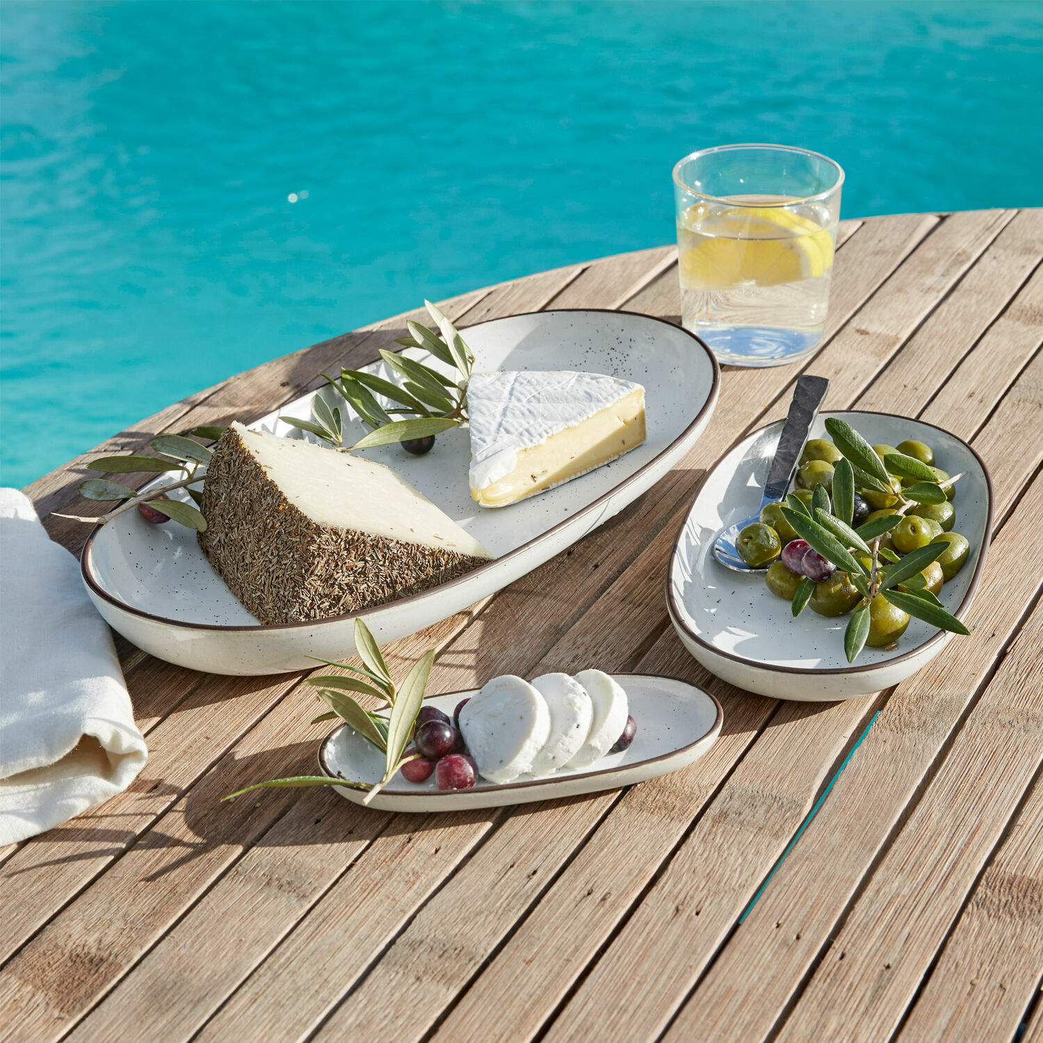 Set di 3 vassoi Biarré Set di piatti ovali in ceramica color crema su tavolo in legno con formaggi e olive