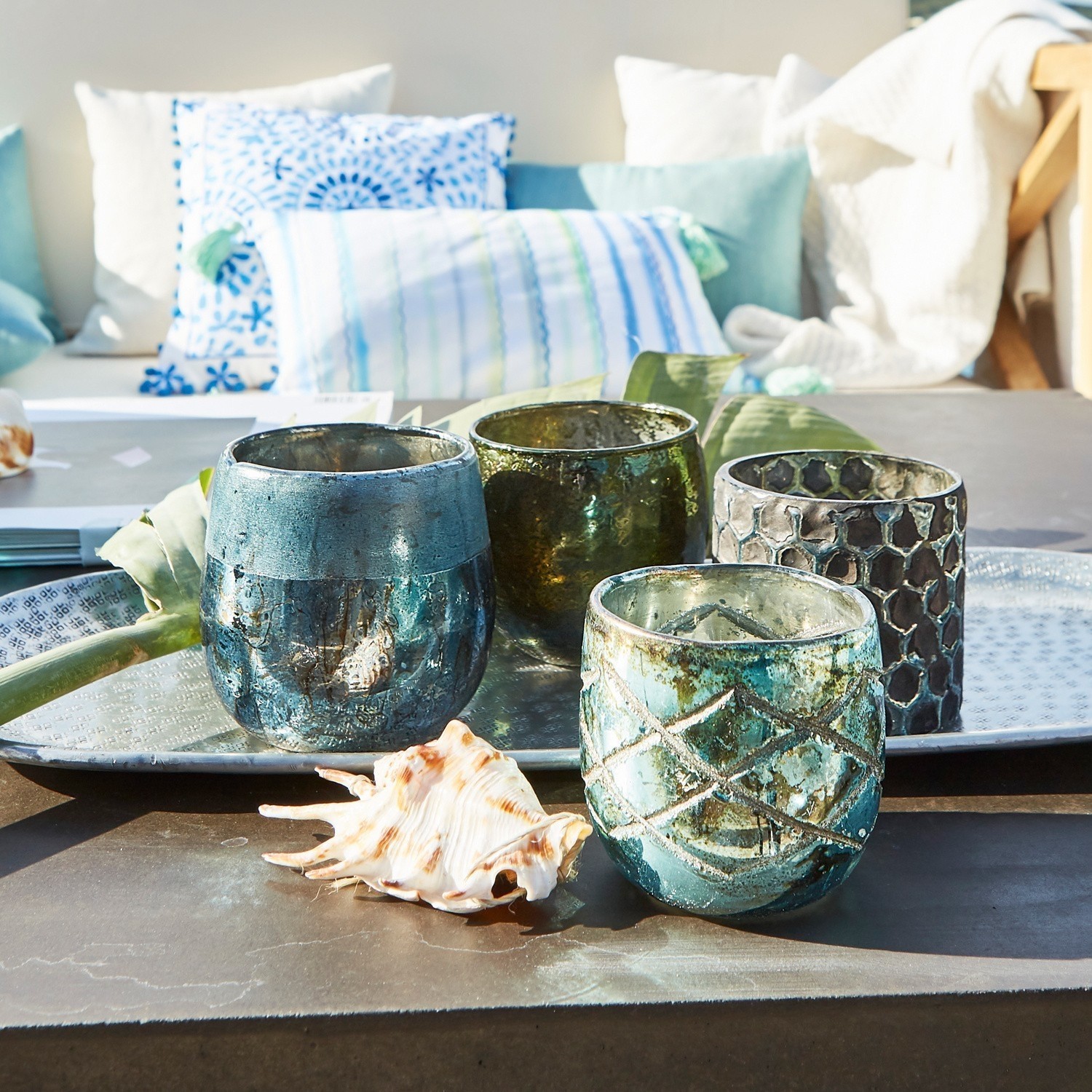 Set di 4 portalumini Marine Set di quattro portacandele in vetro blu e verde su vassoio in metallo con conchiglia decorativa