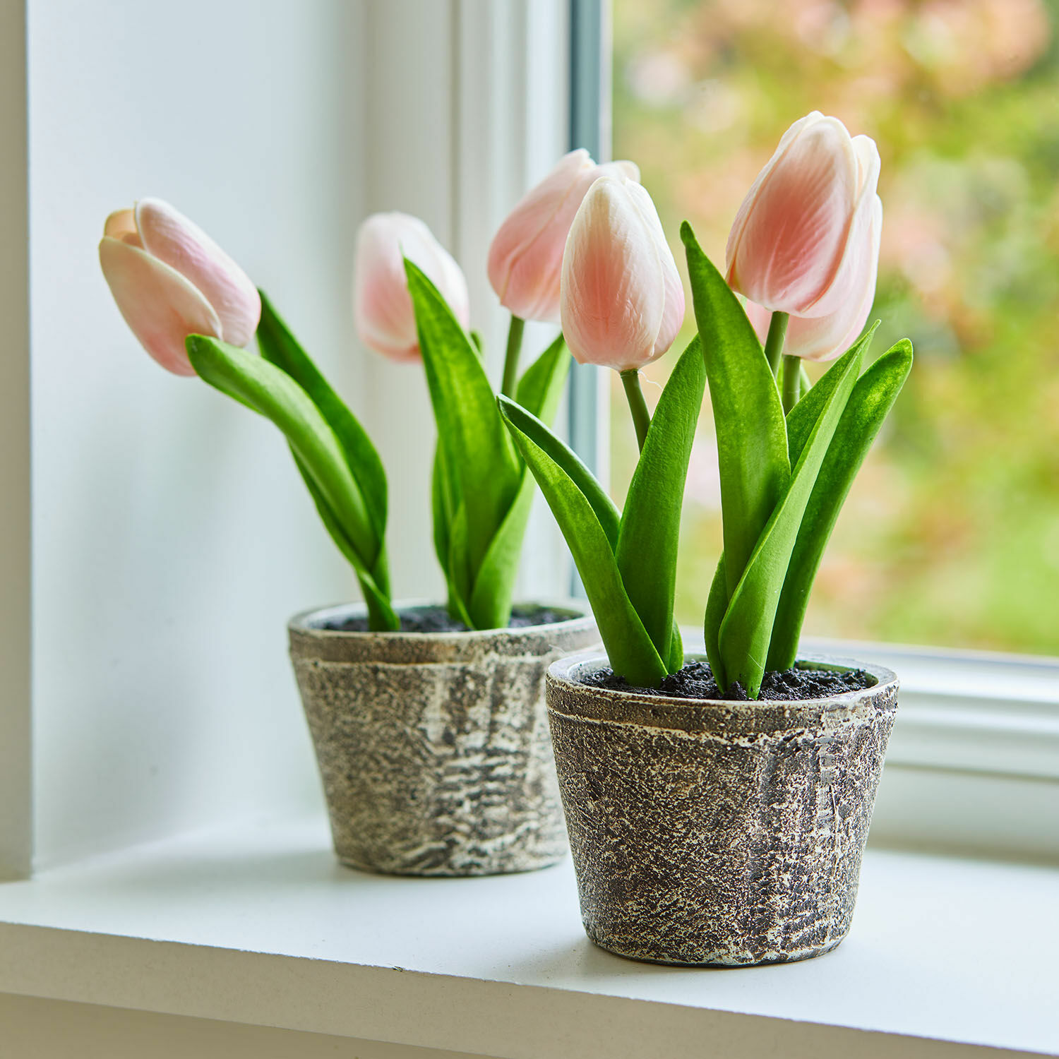 Coppia di vasi con tulipani decorativi Zéphine Delicati tulipani rosa in vasi di pietra grigia sul davanzale, decorazione primaverile