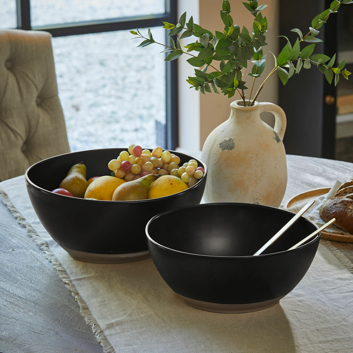 Coppia di insalatiere Biarré Due ciotole in ceramica nera con verdure verdi su tavolo di legno chiaro