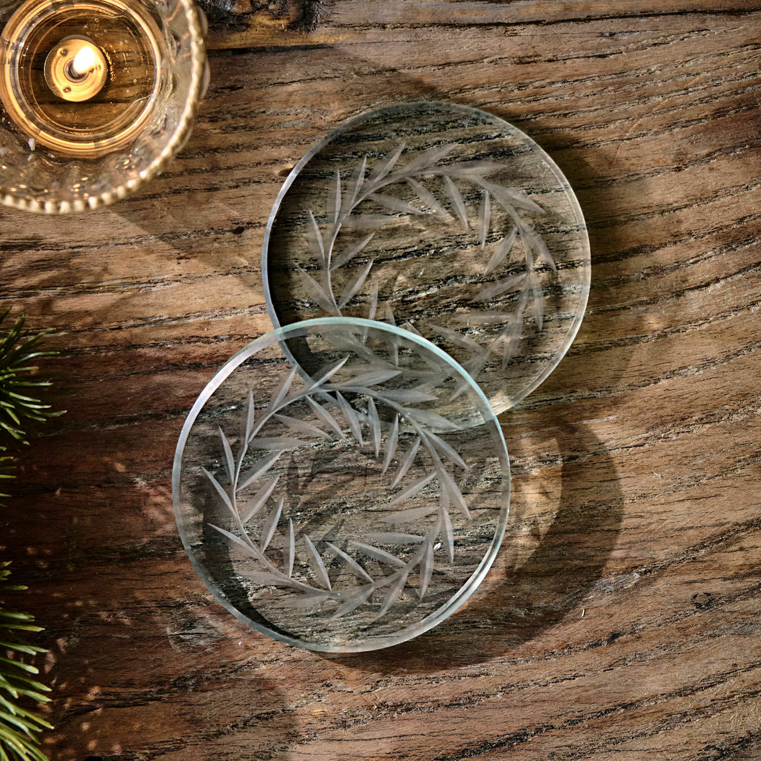 Coppia di sottobicchieri Altheris Sottobicchieri in vetro trasparente con motivo inciso a foglie su tavolo in legno, decorazione elegante