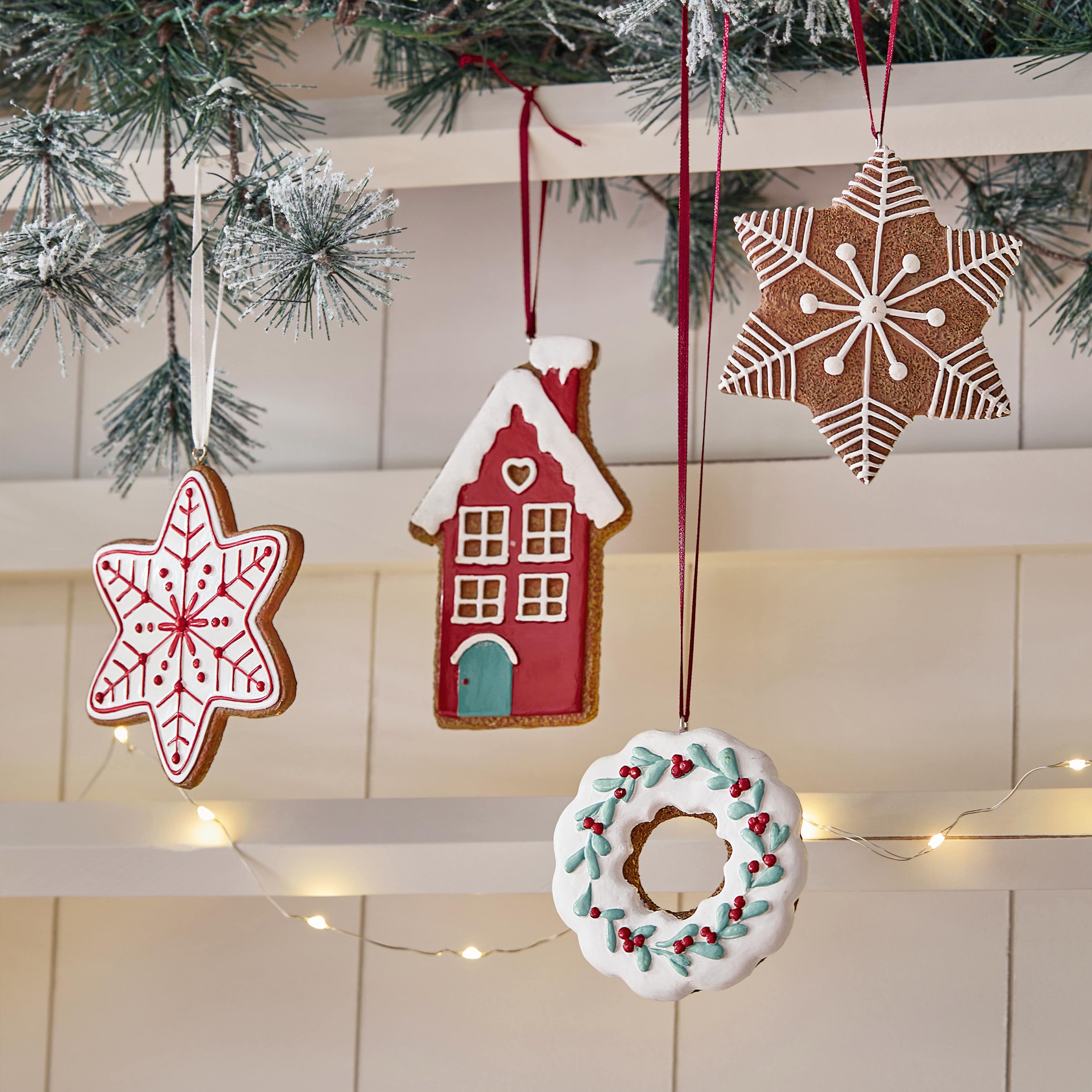 Decorazioni natalizie di pan di zenzero a forma di stella, casa e corona con glassa colorata appese