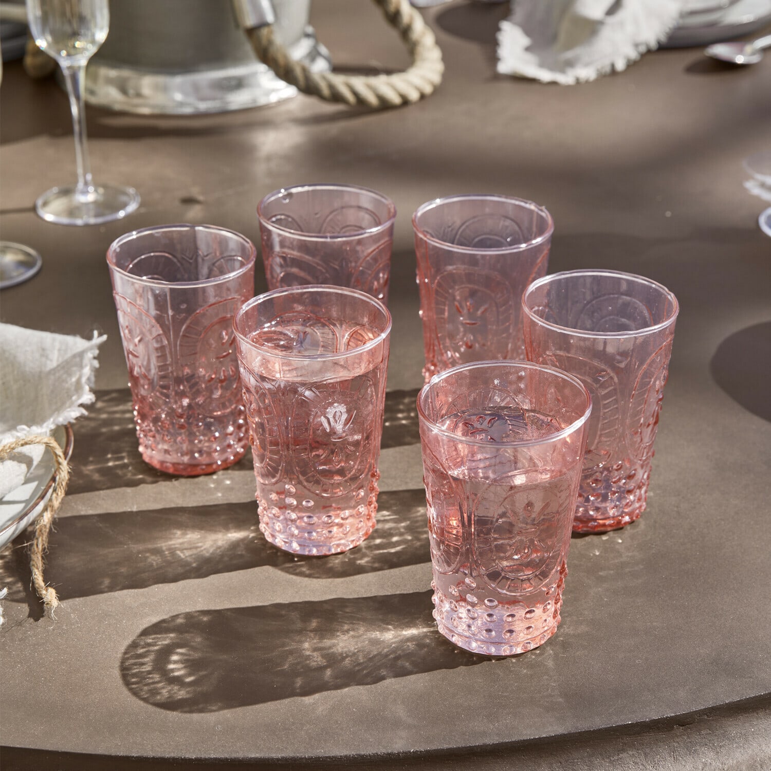 Set di 6 bicchieri Fleury Set di sei bicchieri rosa con motivo decorativo su tavolo marrone per bevande