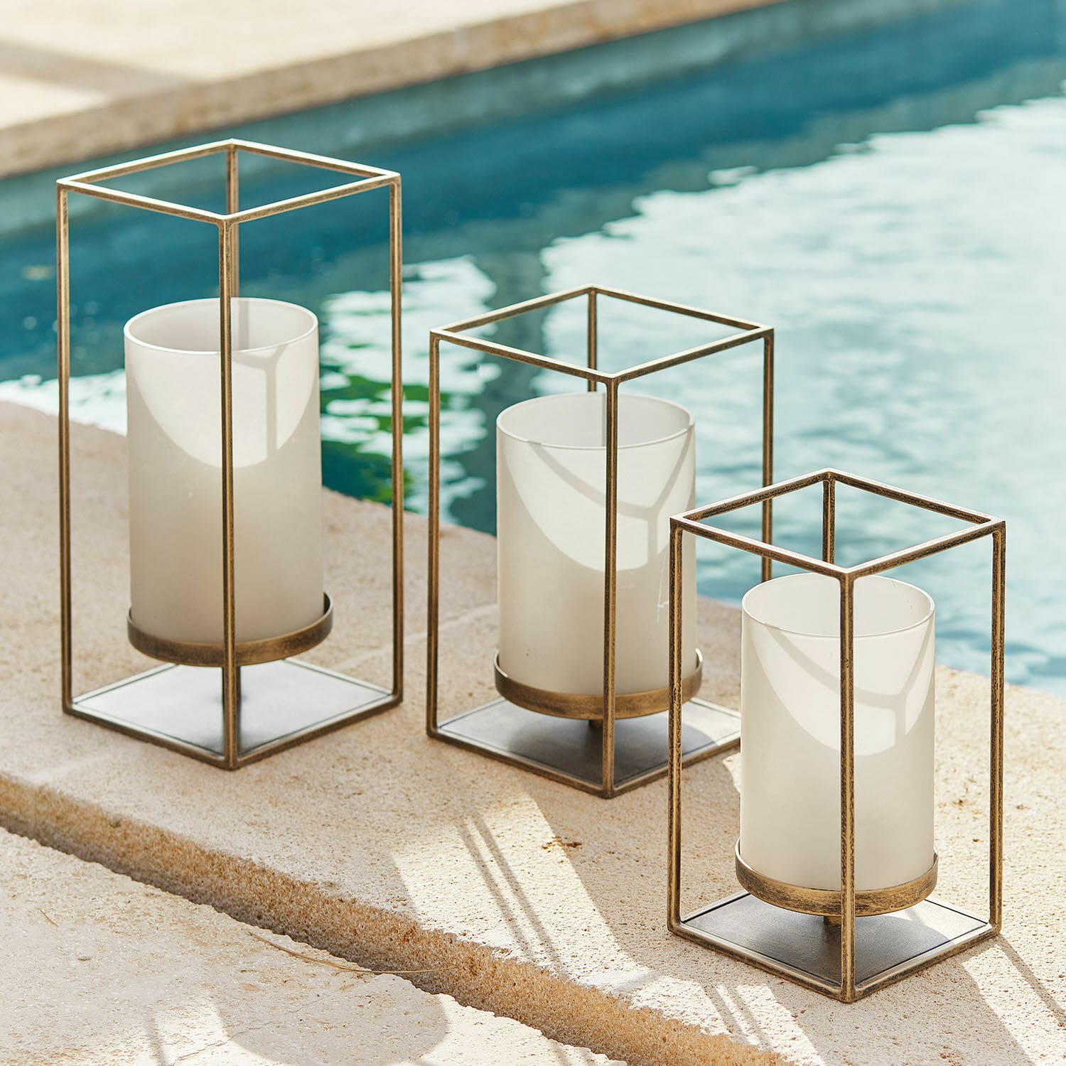 Set di 3 portacandele Vauxandre Set di tre lanterne in metallo color oro antico con paralumi in vetro bianco per candele