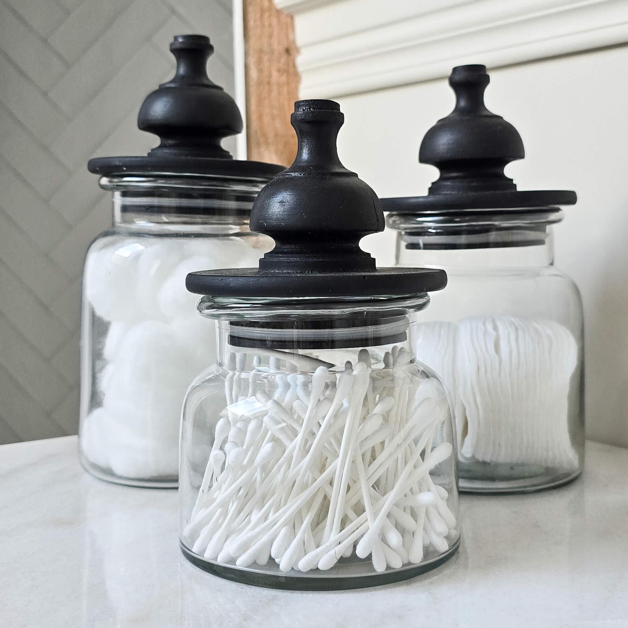 Barattoli di vetro con coperchi neri per cotone e cotton fioc in bagno