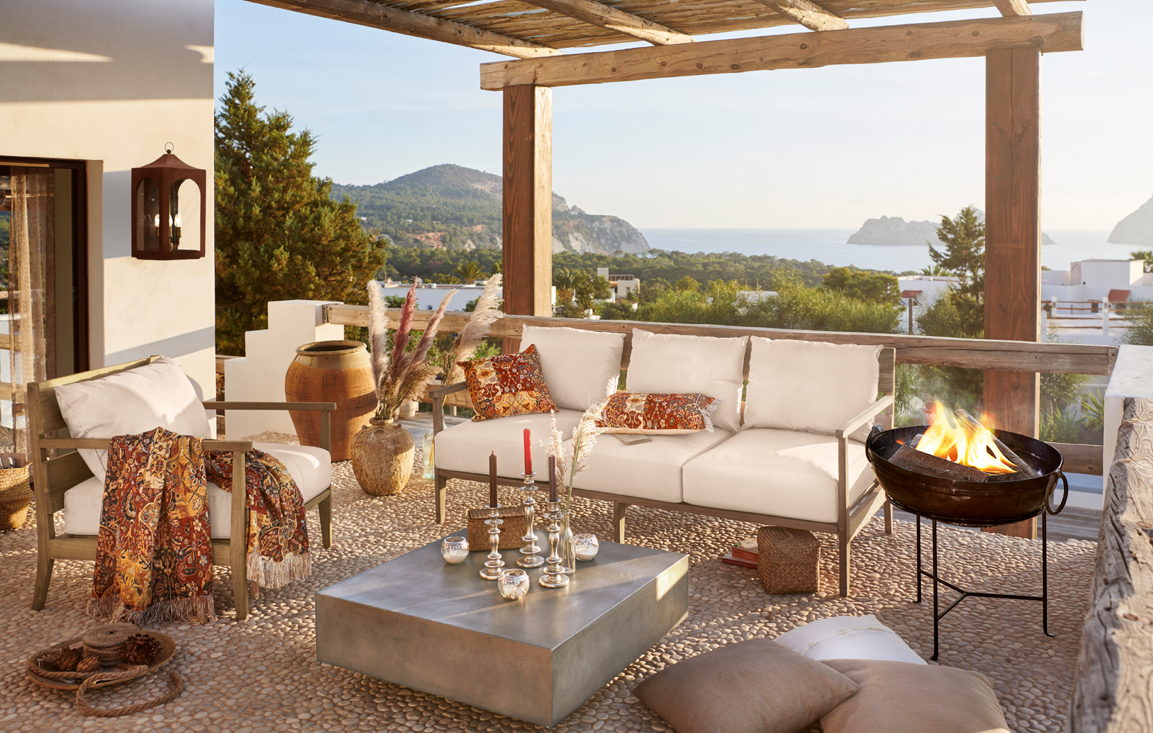 Accogliente terrazza con cuscini beige e dettagli orientali con vista su mare e montagne
