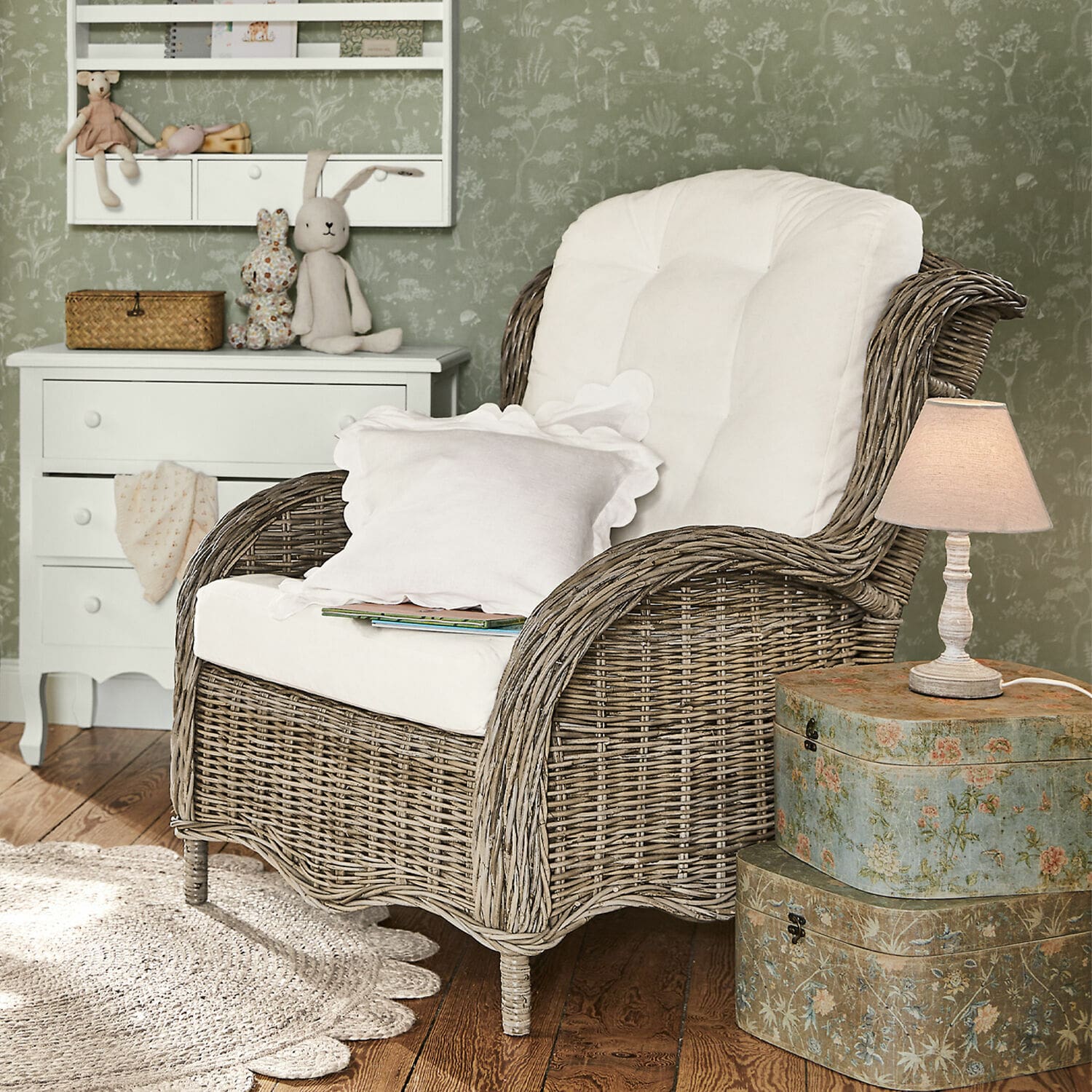 Poltrona Hailee Poltrona in vimini con cuscino bianco in ambiente accogliente con lampada e cassettiera