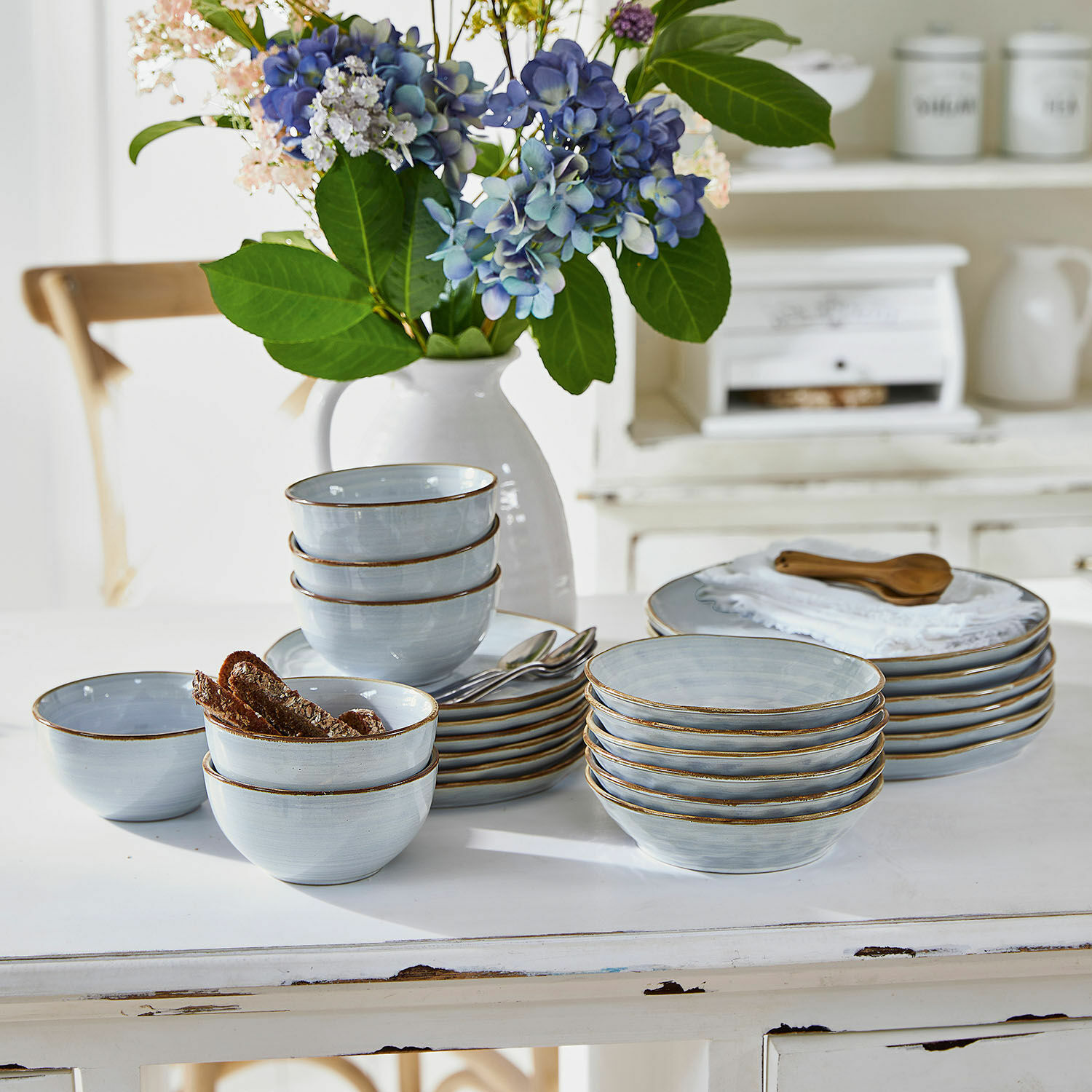 Servizio di 24 stoviglie Veena Set di ciotole e piatti in ceramica azzurri con bordo marrone su tavolo bianco