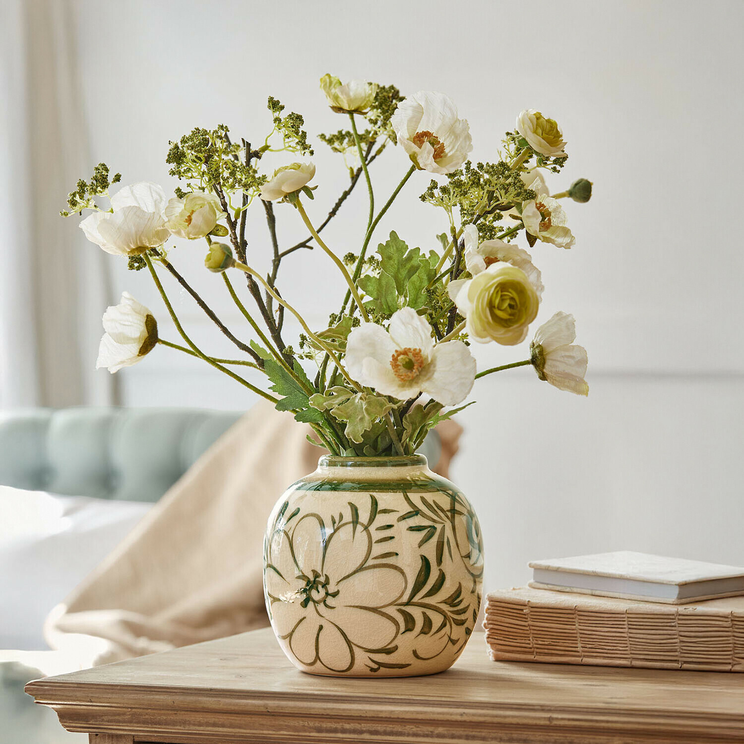 Vaso Avignonel Vaso in ceramica beige con motivi floreali verdi e fiori bianchi artificiali su tavolo in legno