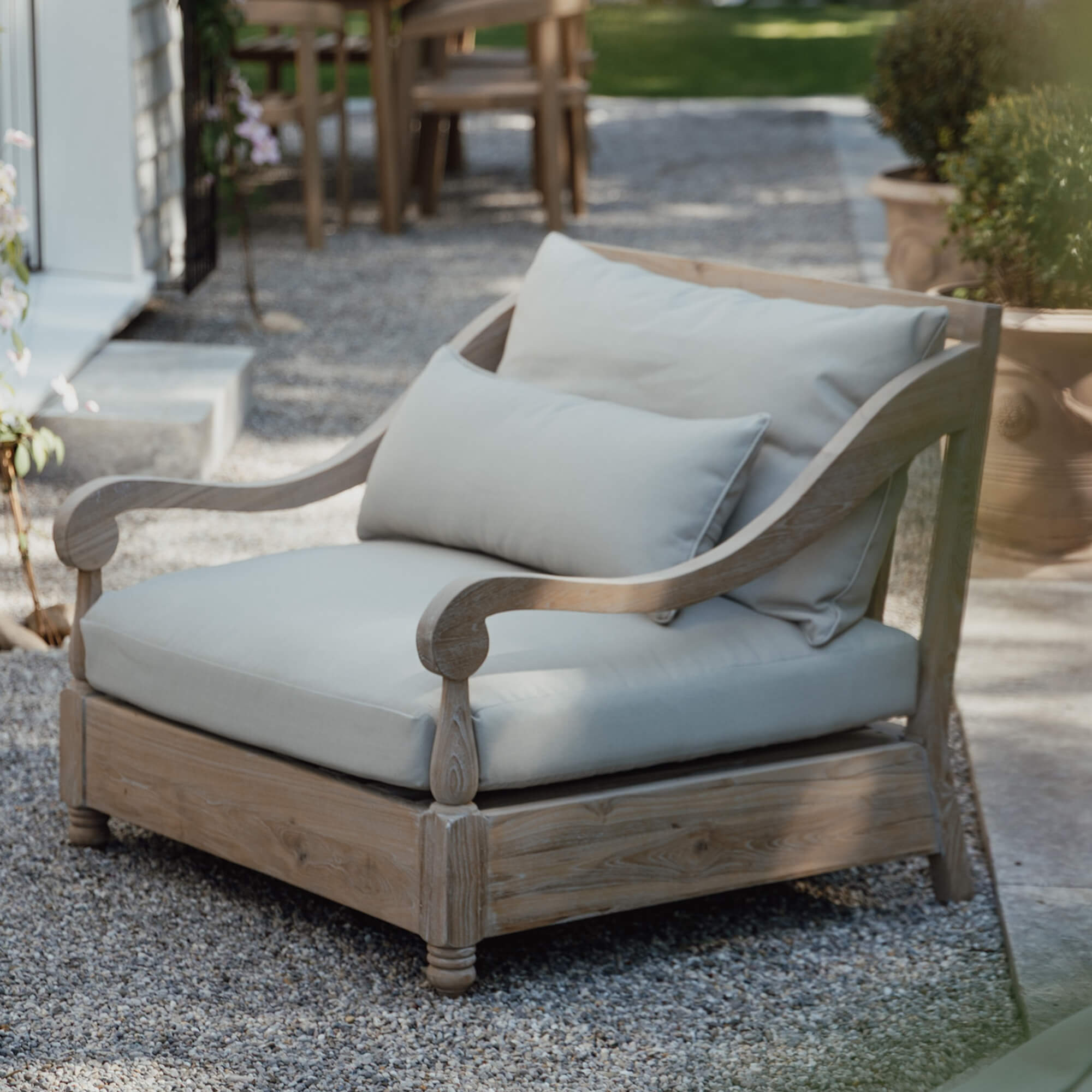Divano da giardino in legno chiaro con cuscini crema, mobili confortevoli per terrazza