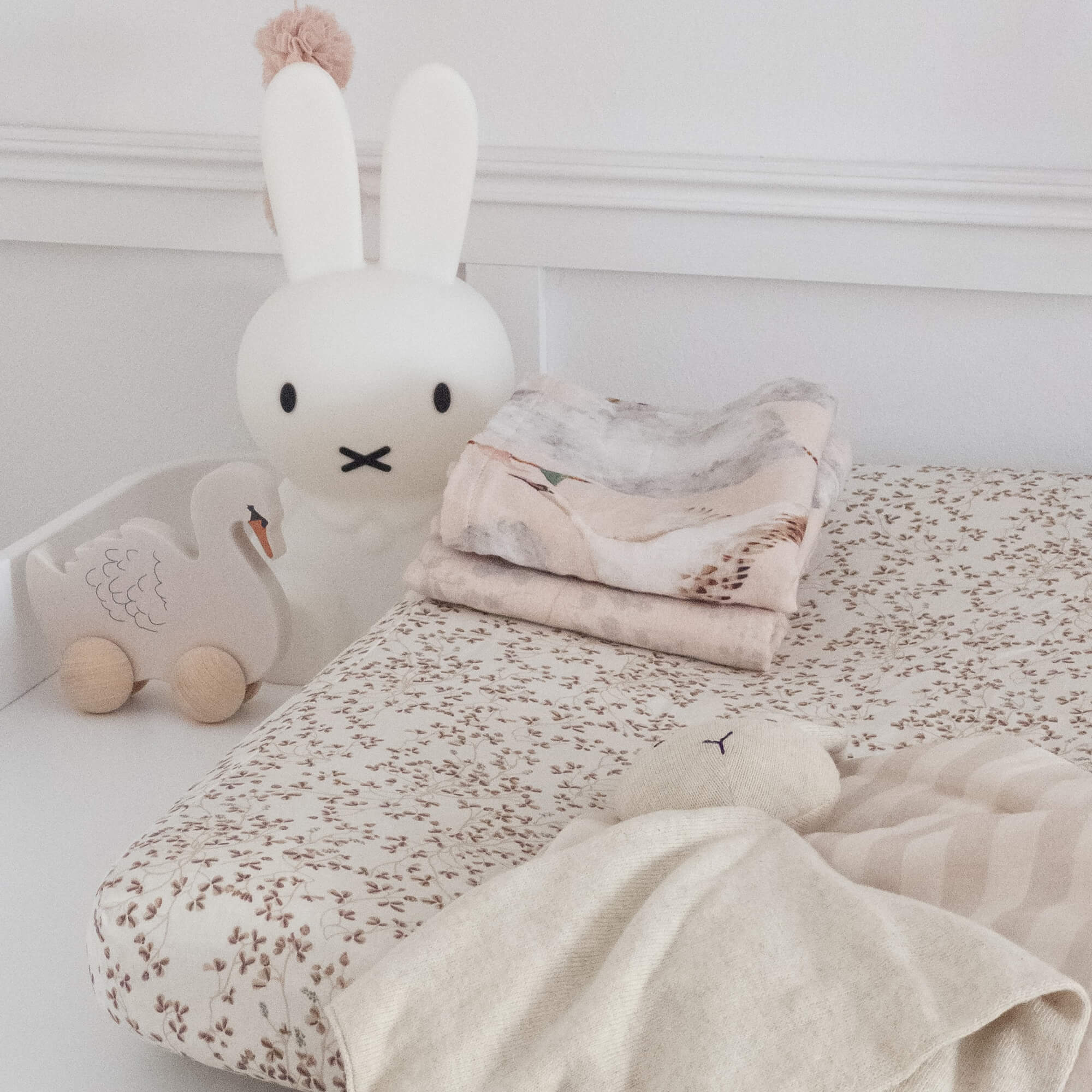 Biancheria da letto per bambini beige con motivo e morbido peluche coniglio su letto in stanza luminosa