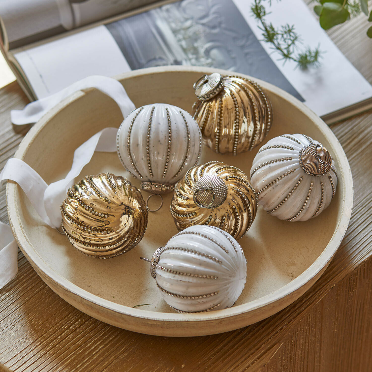 Set di 6 palline morbide da dessert Shaela Set di palline di Natale bianche e dorate con finitura metallica in ciotola rotonda su tavolo in legno