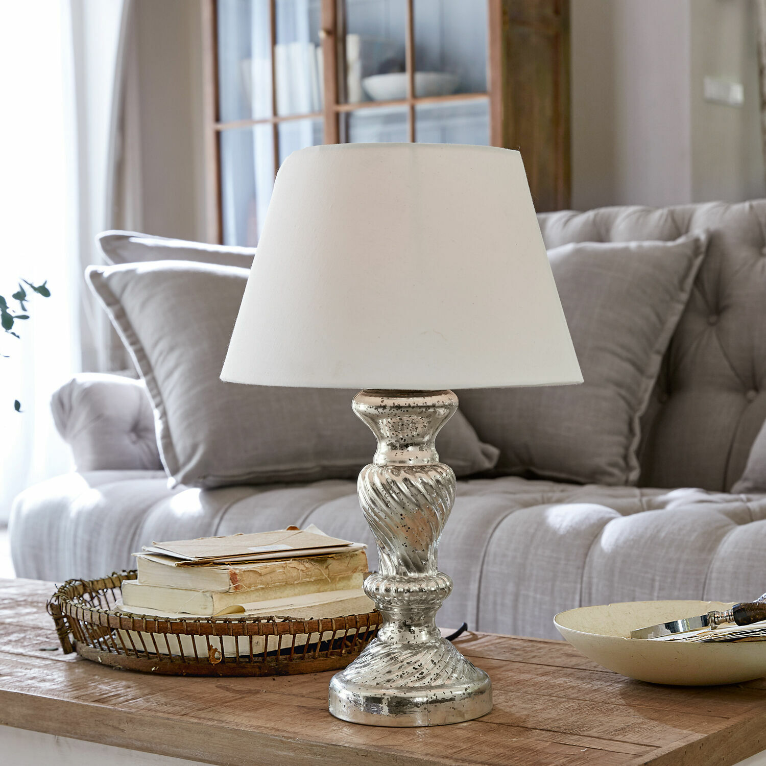 Lampada da tavolo Hazel Lampada da tavolo con paralume bianco e base argentata su tavolo in legno in soggiorno