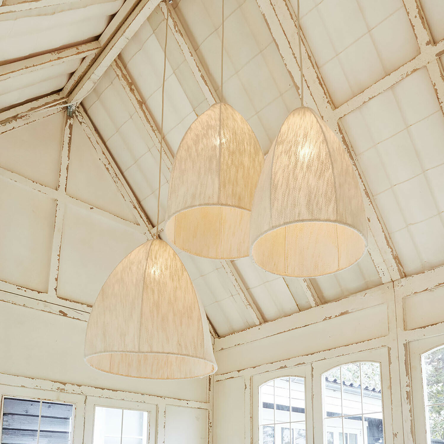 Set di 3 lampade a sospensione Reveaux Tre lampade a sospensione in tessuto chiaro a forma di campana in interno rustico con soffitto bianco