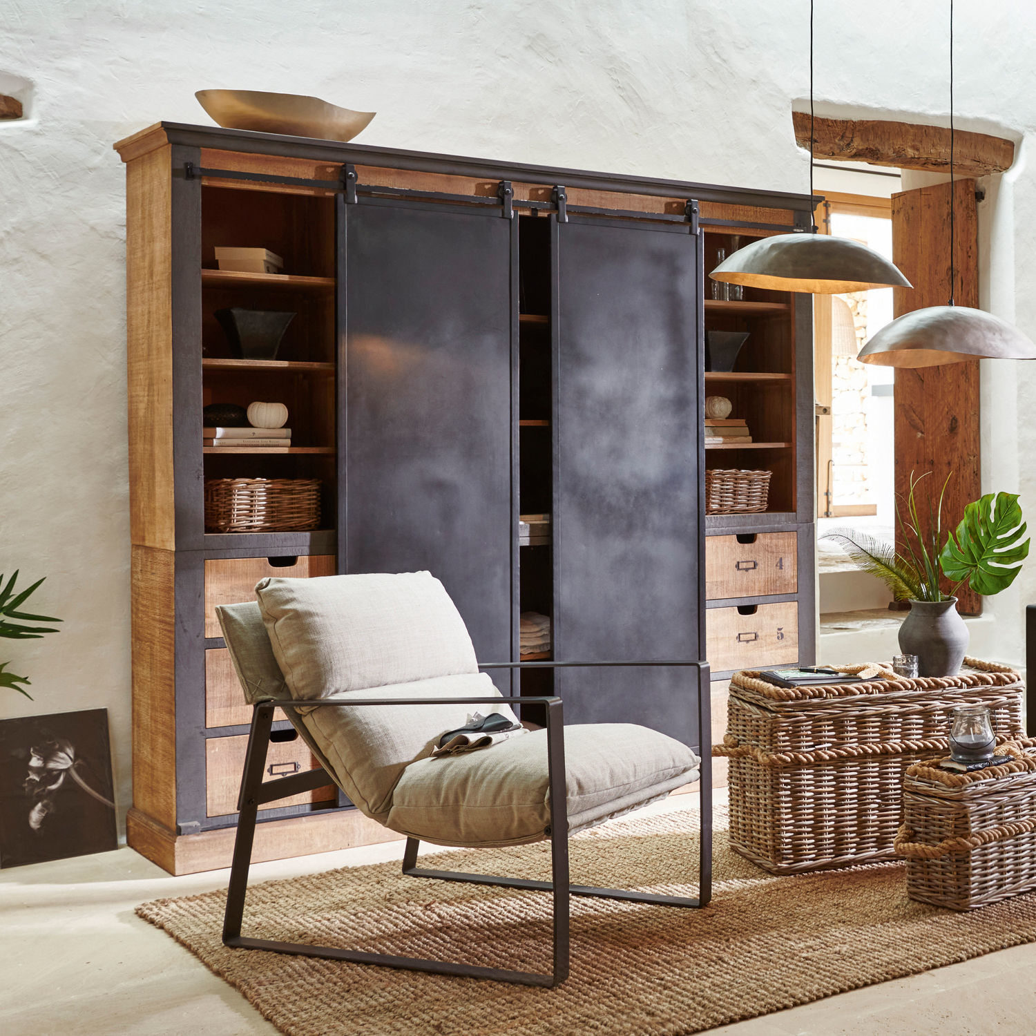 Armadio Vulmont Poltrona moderna con struttura in metallo e cuscino beige in soggiorno naturale con cesti di vimini