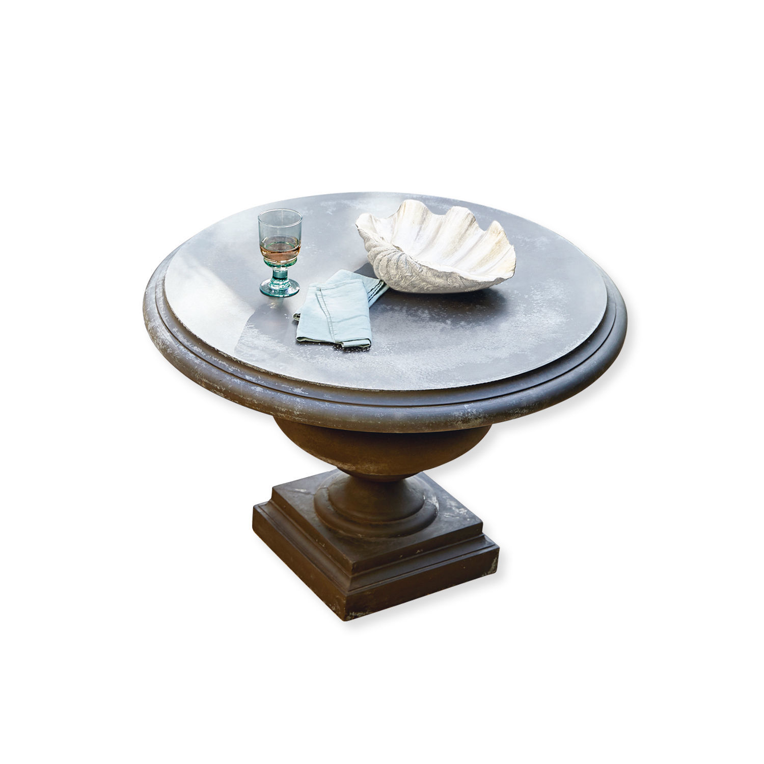 Tavolo Monterey Tavolo rotondo con piano in metallo e base scura, decorato con bicchiere e conchiglia bianca