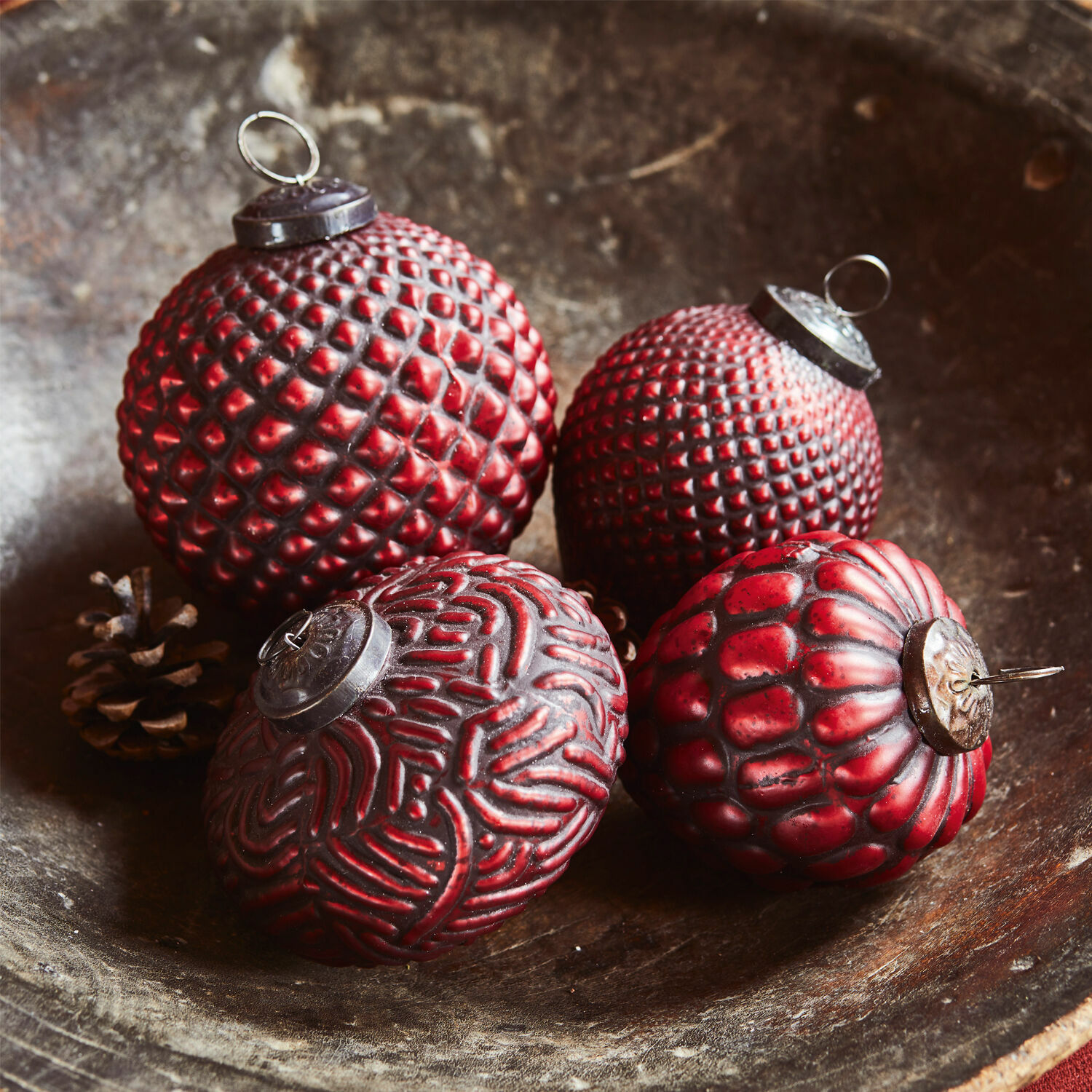 Set di 4 decorazioni natalizie Meyen Quattro palline di Natale rosse con diverse texture in una ciotola di legno, decorazione festiva