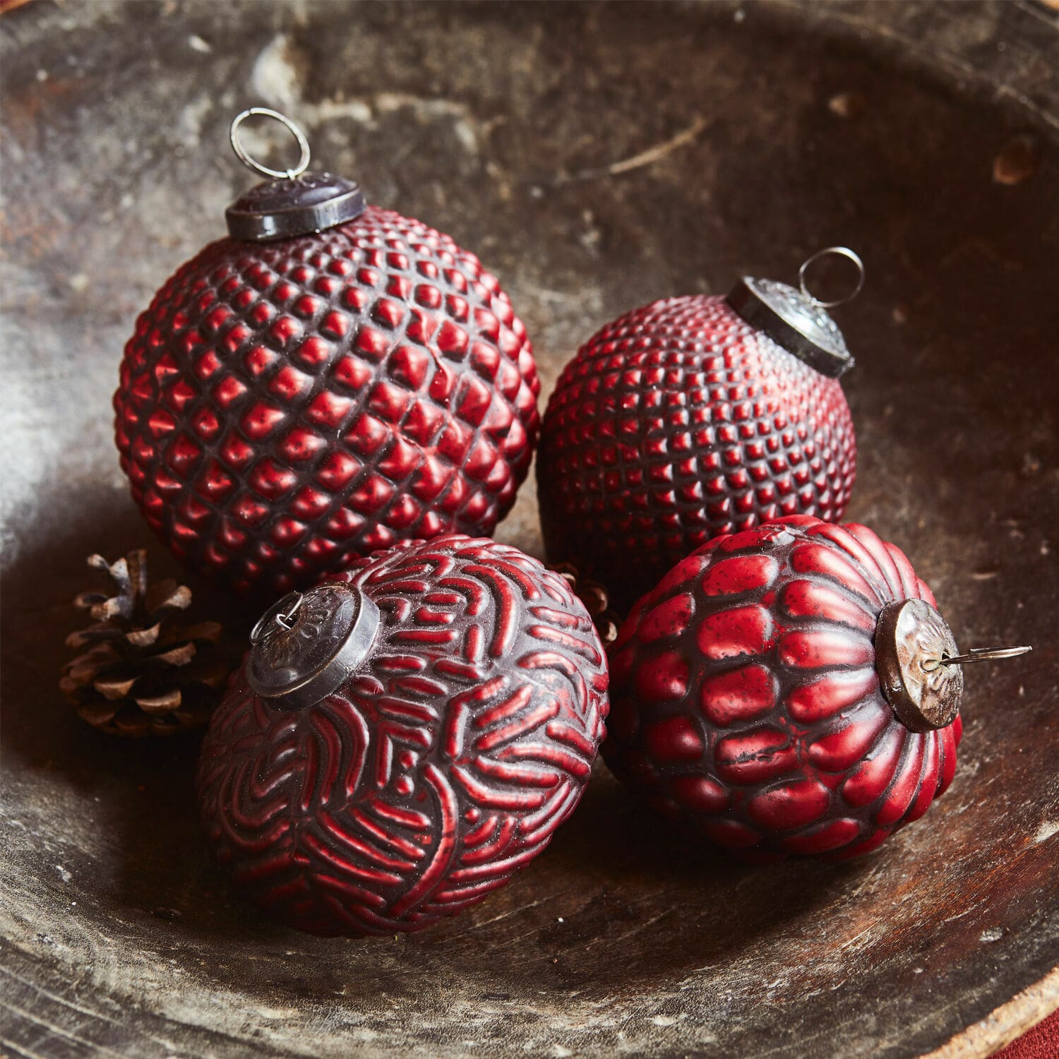 Set di 4 decorazioni natalizie Meyen Quattro palline di Natale rosse con diverse texture in una ciotola di legno, decorazione festiva