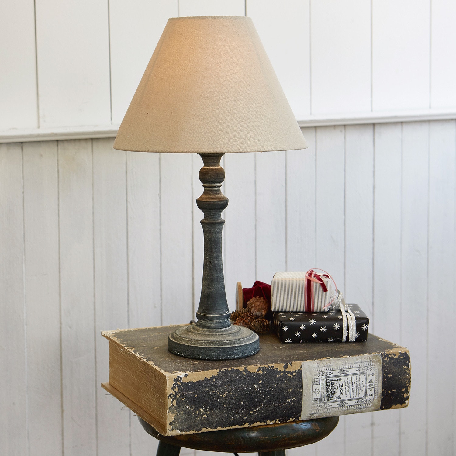 Lampada da tavolo Withby Lampada da tavolo con paralume beige e base nera invecchiata su sfondo bianco