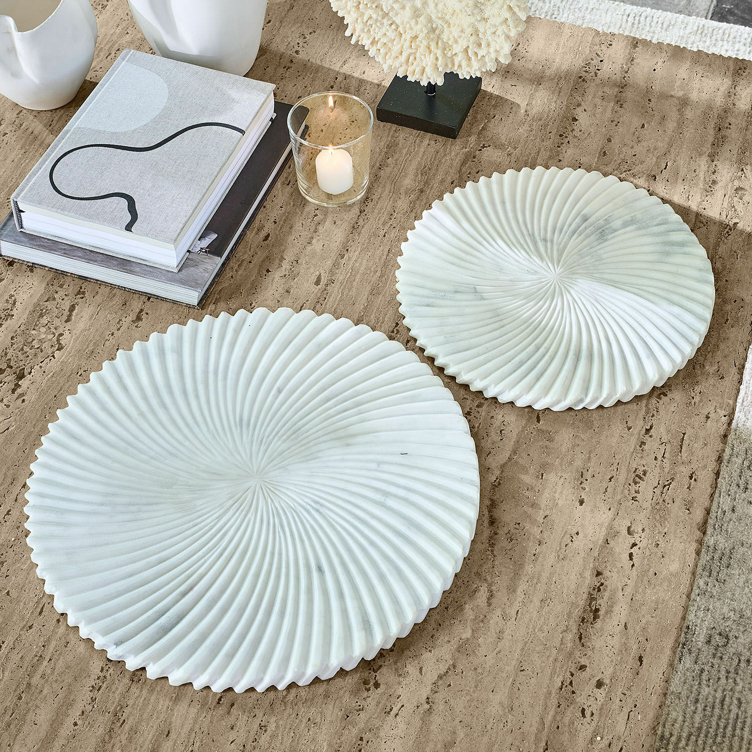 Set di 2 ciotole Bellarivas Due piatti decorativi bianchi in marmo con motivo ondulato su tavolo beige, decorazione d'interni