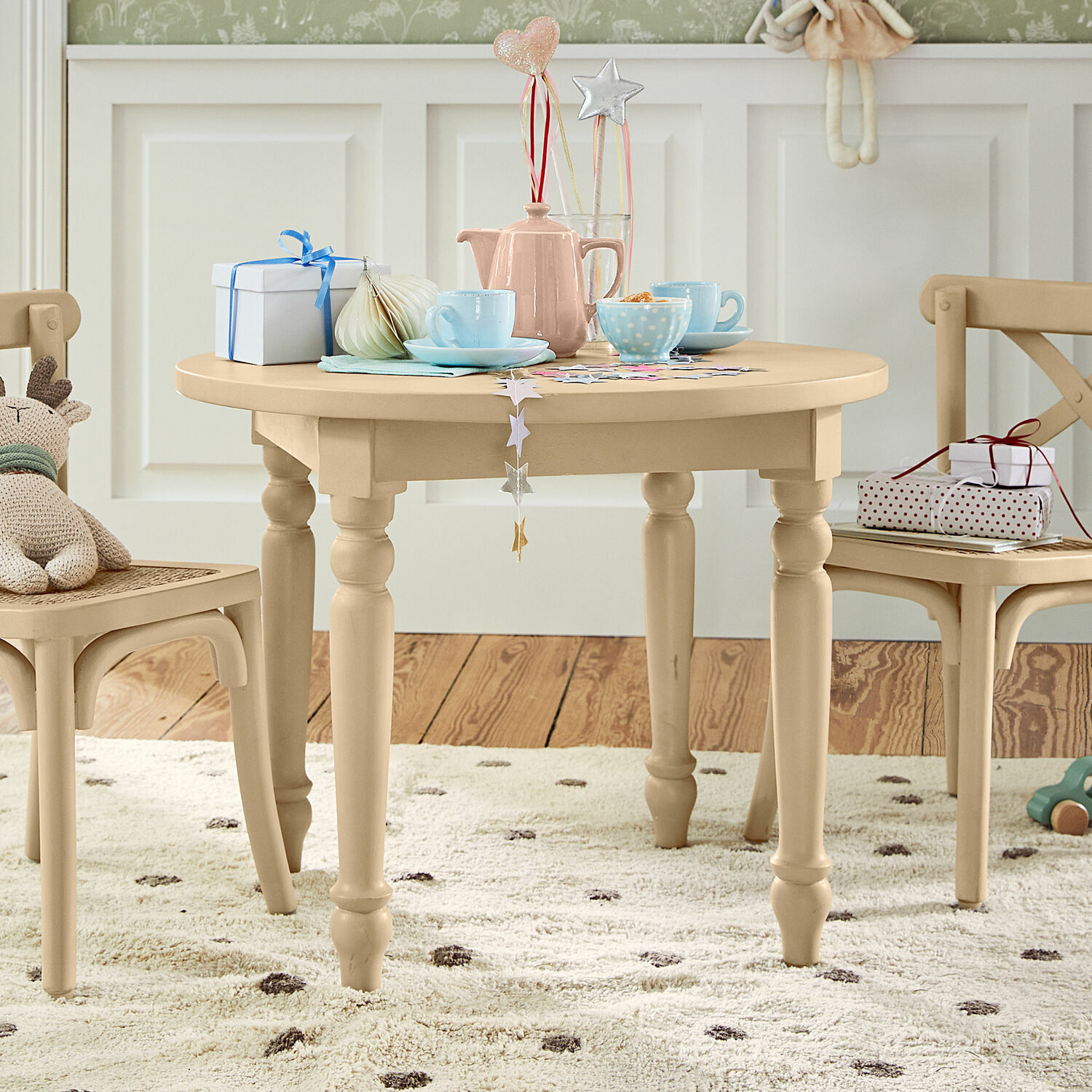Tavolino per bambini Sourila Tavolo rotondo per bambini in legno beige con decorazioni e giocattoli su tappeto a pois