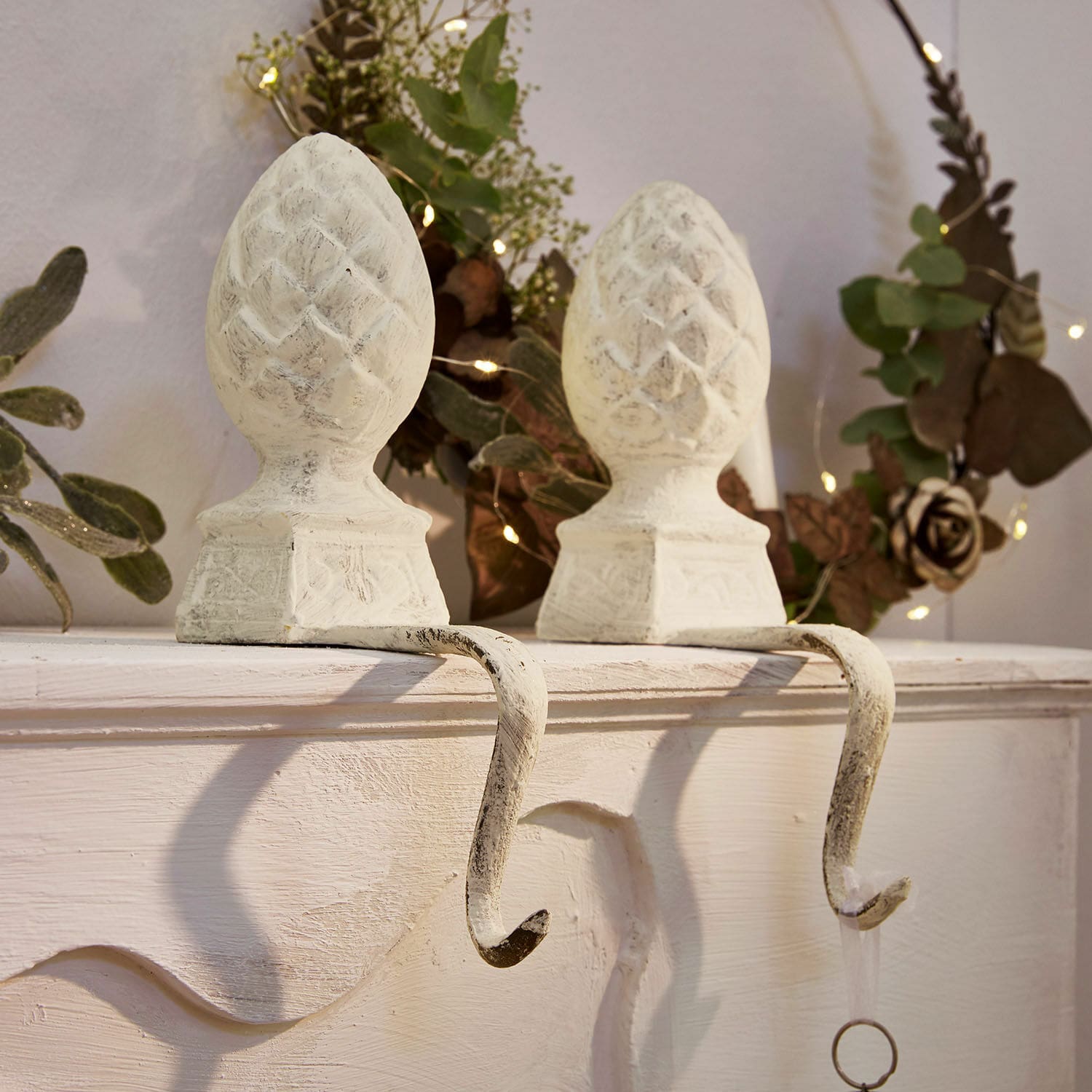 Coppia di ganci in metallo bianco con decorazione a pigna per appendere decorazioni