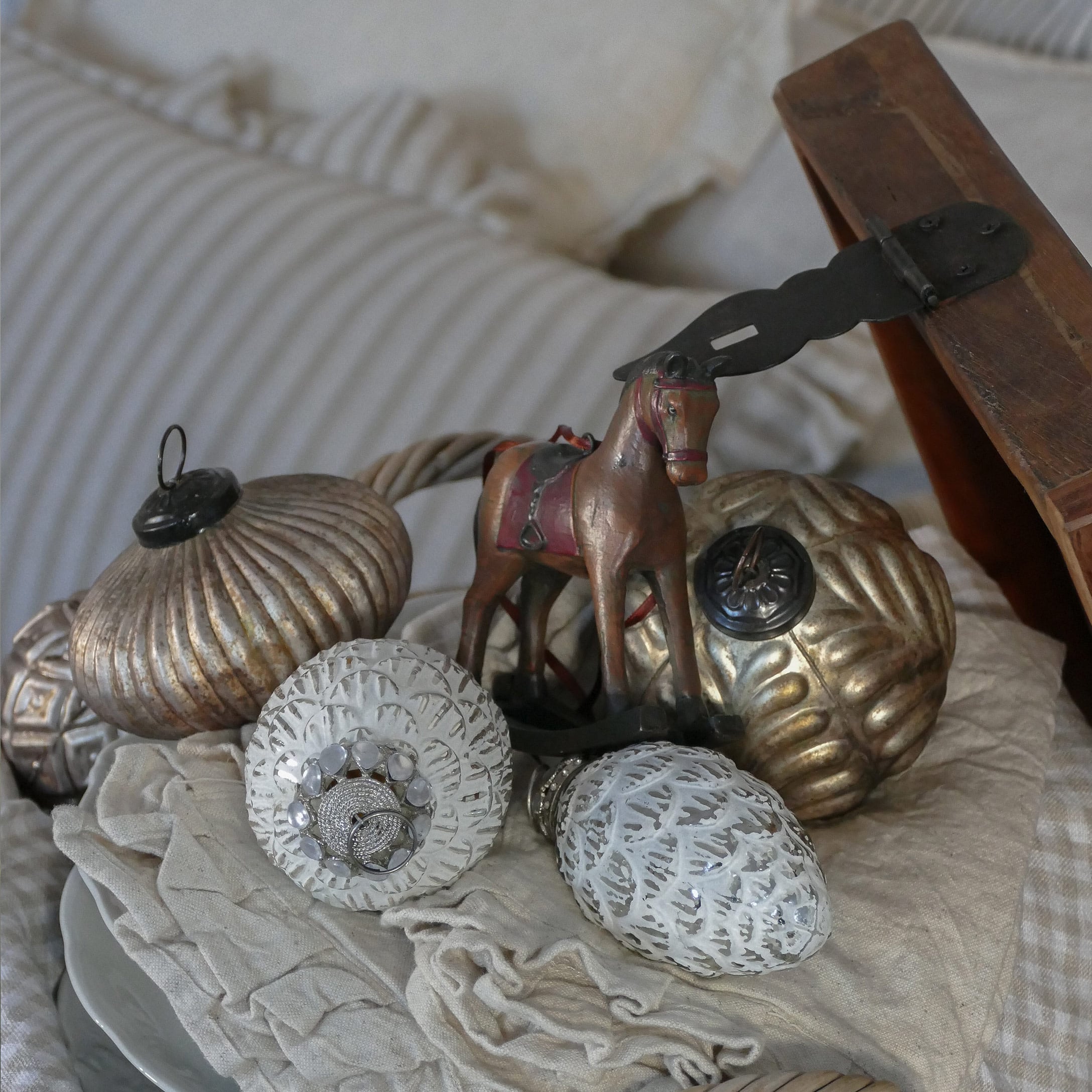Decorazioni natalizie dorate e bianche con figura di cavallo su tessuto beige