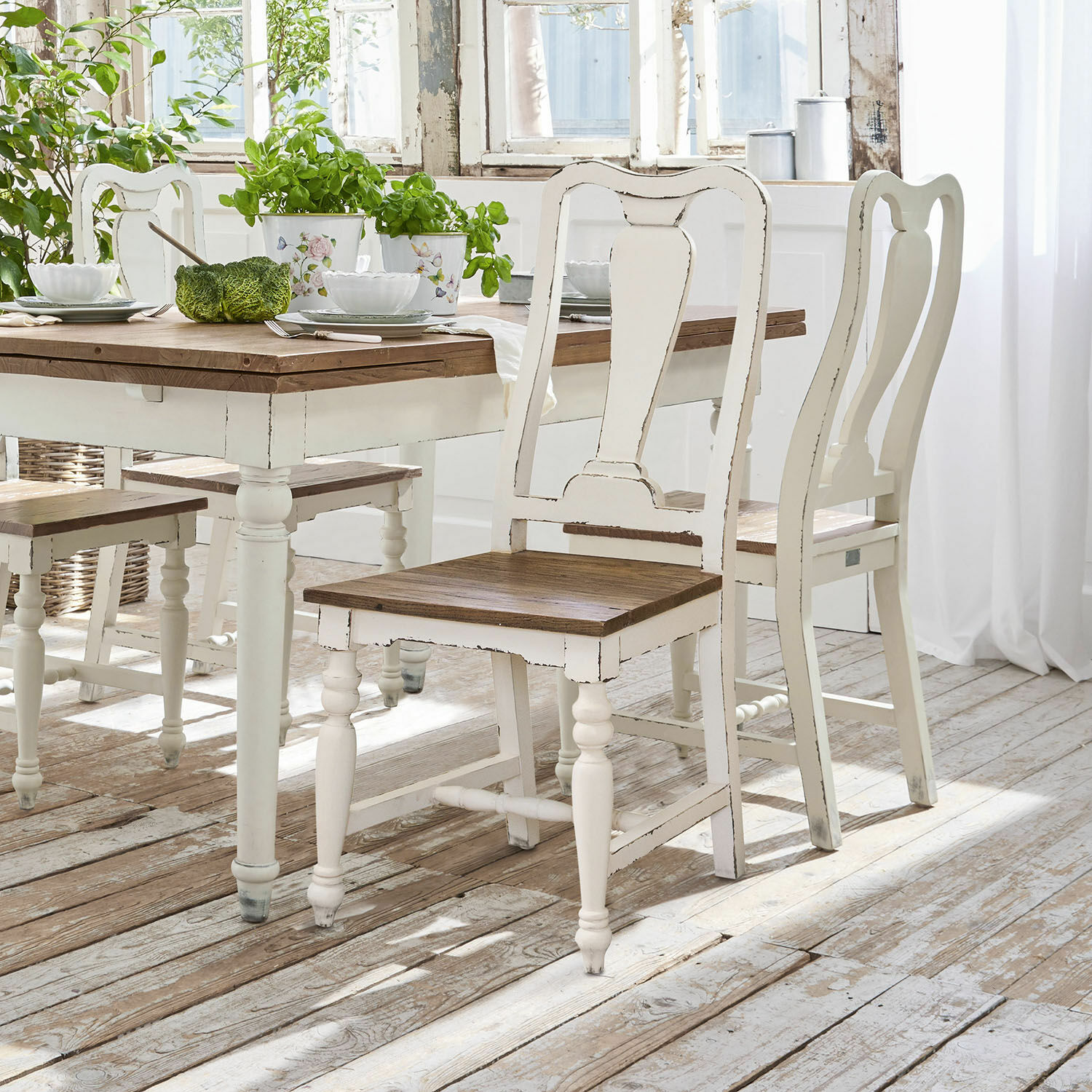 Sedia Harold Sedie e tavolo in legno bianco con piano marrone in una luminosa sala da pranzo rustica